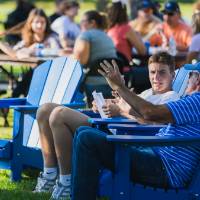 People talking and sitting in lawn chairs on Kirkhof Lawn.